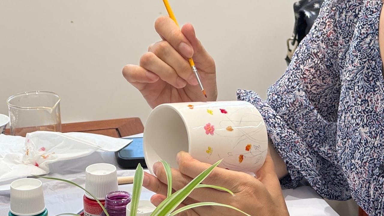 作者參與彩繪瓷杯的活動。（作者提供）