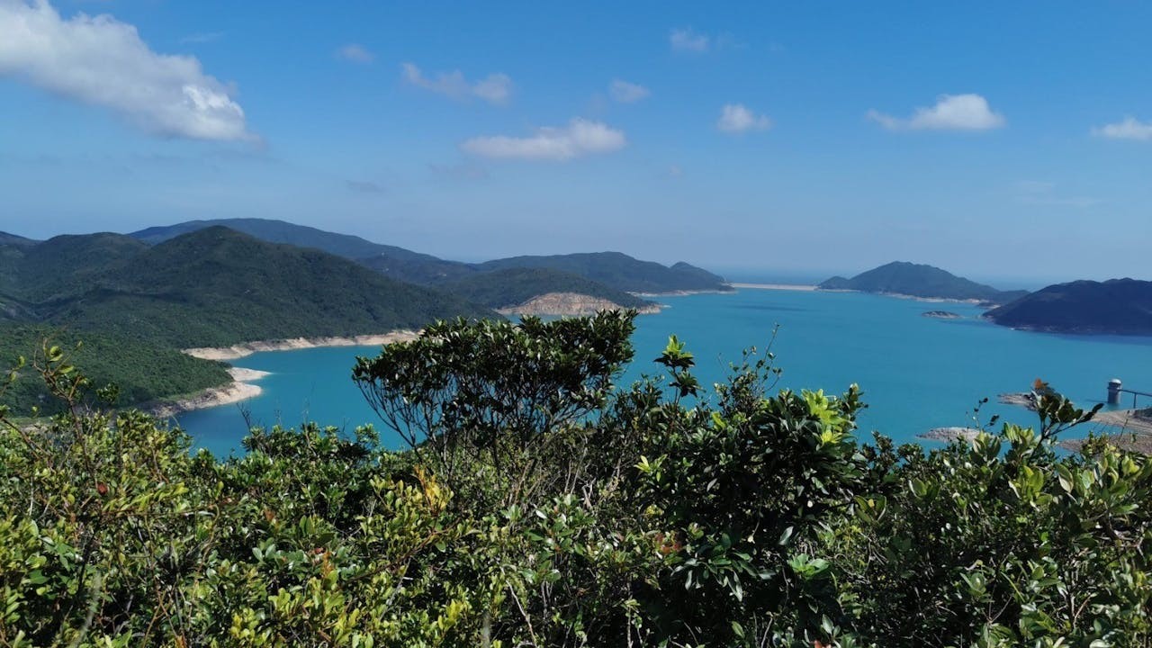 擺頭墩東望萬宜水庫，遠處東壩連接右側糧船灣洲，左側西貢半島。水庫位置原為海峽，稱官門水道，沿岸原有客家村聚落，水道有蜑民艇戶，因建水庫分別被遷往西貢墟萬宜灣新村、沙咀新村及對面海官門漁民新村、萬宜漁村。