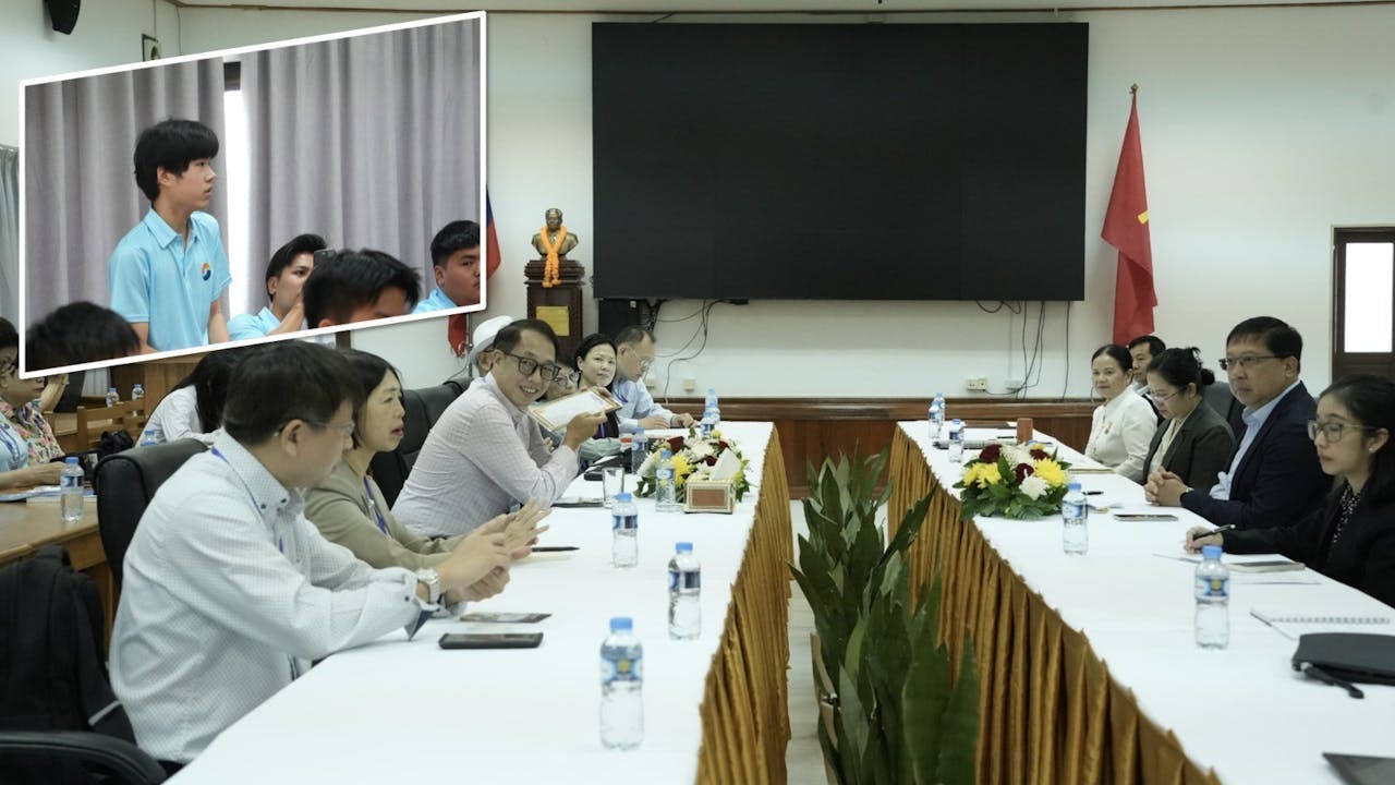 在老撾教育和體育部，莊太量教授與 Mr Kingmano 副部長交流。坐在席上的我舉起手來，跳出自己的安舒區。（小圖為作者）