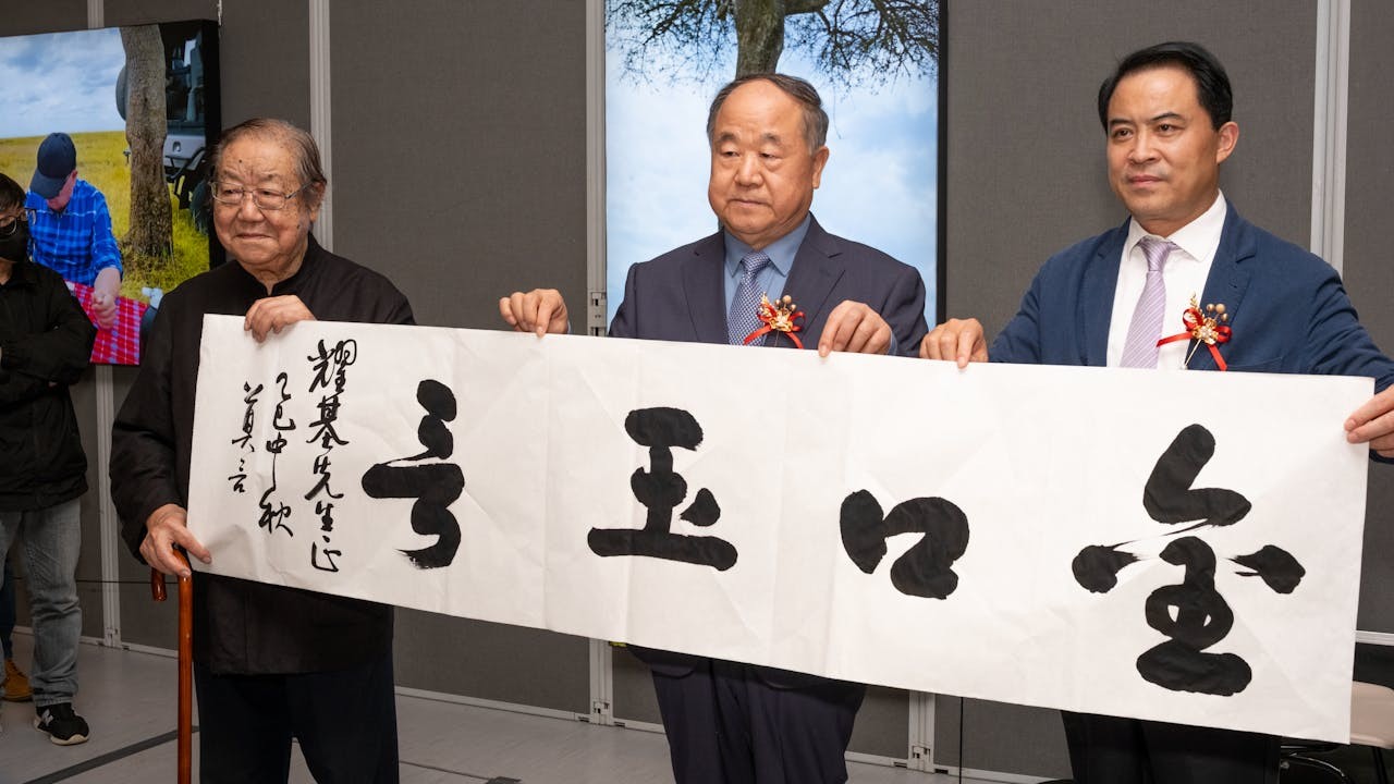 莫言（中）、王振（左）和金耀基（右）開幕儀式後即席揮毫，莫言書寫了「金口玉言」四字。（大會提供）