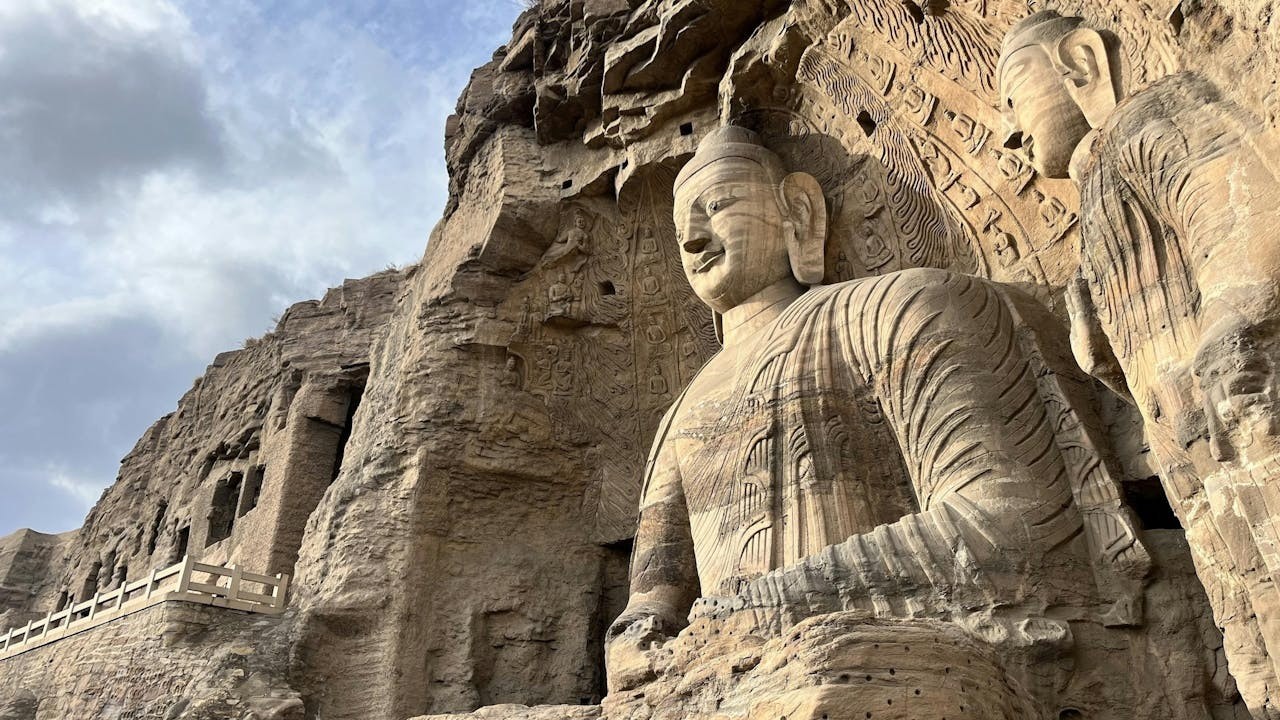 露天大佛直接雕鑿於砂岩崖面,面龐圓潤、鼻樑高挺,衣紋深刻有力,是北魏早期受犍陀羅與中亞藝術影響的代表造像之一。