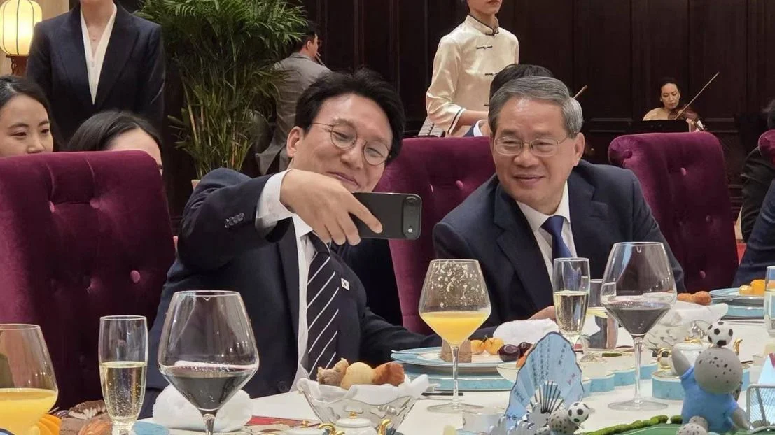 金民錫（左）在大連與國務院總理李強在宴會上自拍。（金民鍚X平台）