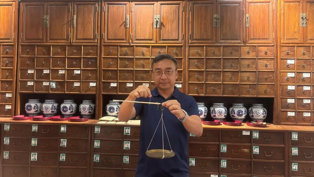 作者在百子櫃前留影。(作者提供)