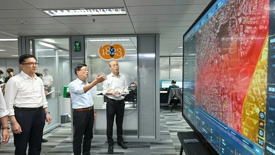 特首李家超(中)、創科及工業局局長孫東(左一)考察1823聯絡中心應用科技情況。(政府新聞處)