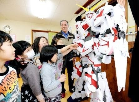 是日本阿公製做的2公尺高鋼彈紙模型展出，並提供相關的團體免費租借這篇文章的首圖
