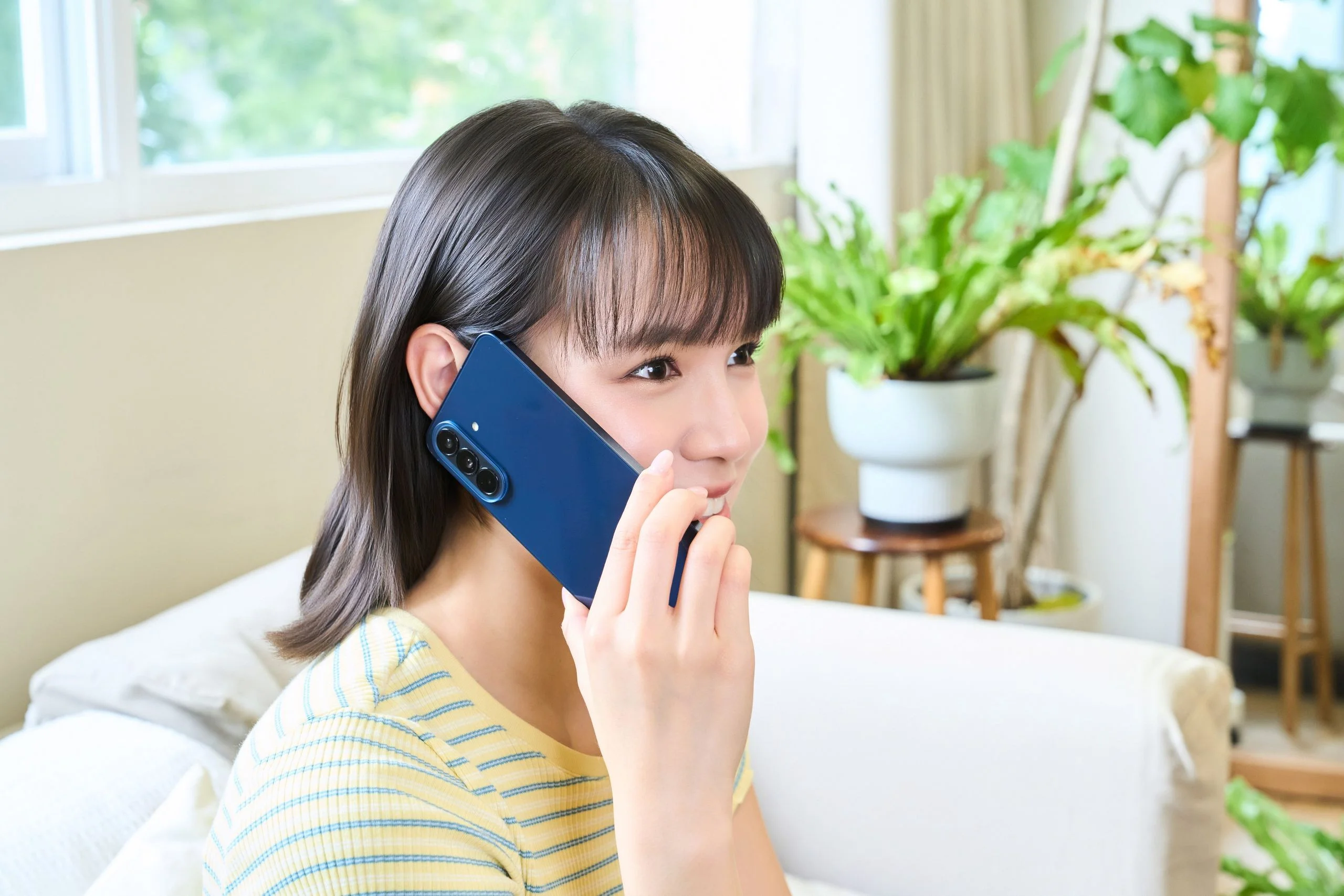 Model 拿著雅痞藍 Galaxy A57 5G 講電話情境照