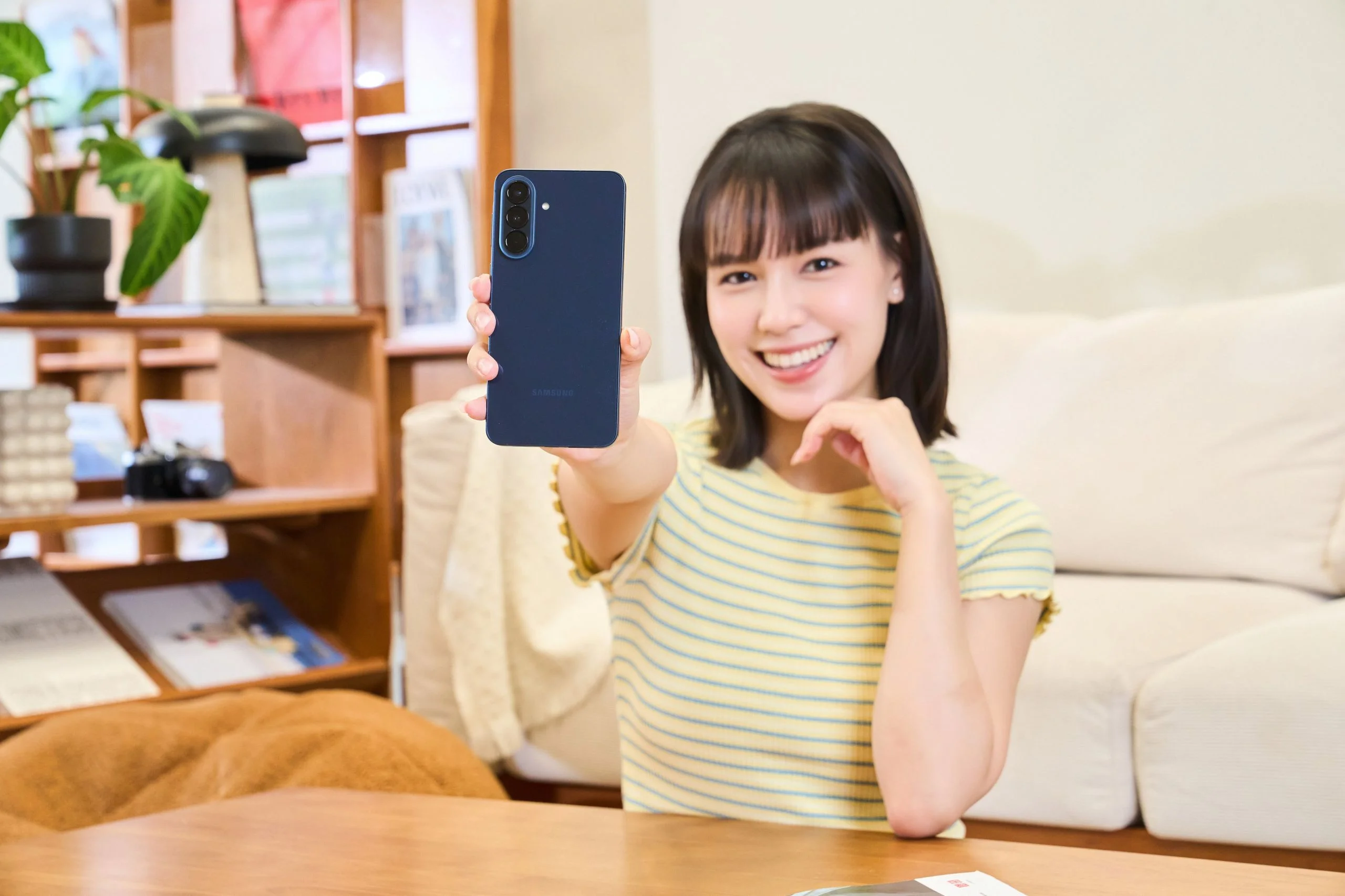 Model 拿著雅痞藍 Samsung Galaxy A57 5G 展示情境照