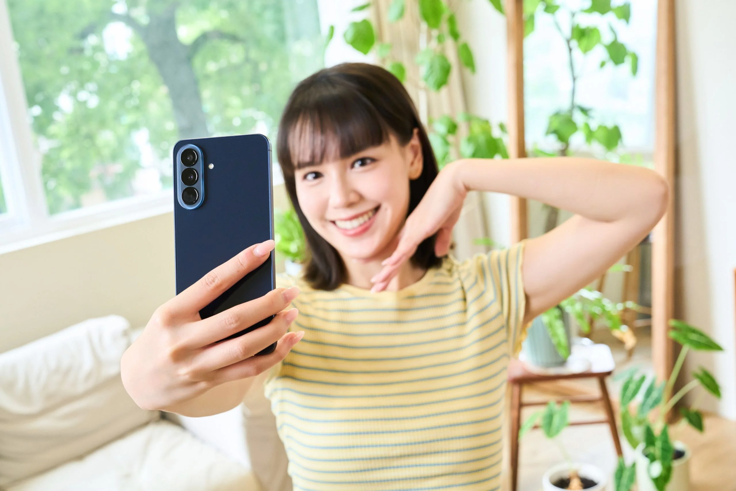 Model 拿著雅痞藍 Samsung Galaxy A57 5G 自拍情境照