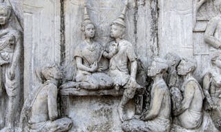 The bas-relief sculpture tells the story of life in ancient times on the old wall.