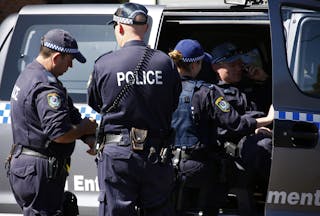 Police talk outside a house that was involved in pre-dawn raids in the western Sydney suburb of Guilford