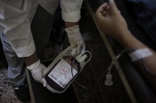 A nurse holds a pack of blood during a donation at the Metropolitan University Center of the San Carlos University, (CUM), in Gu