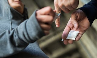 drug trafficking, crime, addiction and sale concept - close up of addict with money buying dose from dealer on street