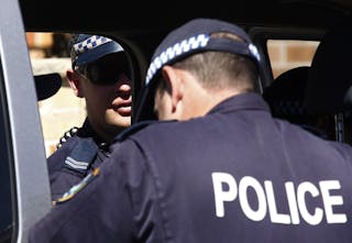 Police stand outside a house that was involved in pre-dawn raids in the western Sydney suburb of Guilford