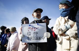 A man holds a board as he waits for Japanese PM and LDP leader Abe's official campaign kick-off for the December 14 lower house 
