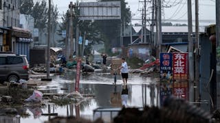 隨著洪水消退，人們開始重建生活，清理家中的泥沙淤積或清洗變成棕色的衣物和家電。