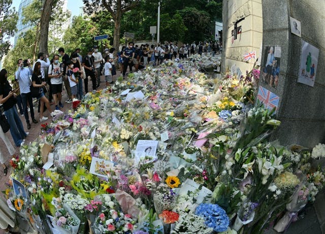 大批香港市民不惜冒着32度高溫、排隊3、4小時到英國領事館弔唁伊利沙伯二世。(亞新社)