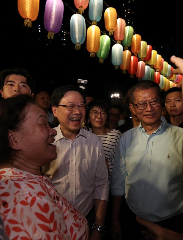 李家超（中）與陳茂波到堅尼地城卑路乍灣中秋夜市，與市民交談。（李家超社交平台）