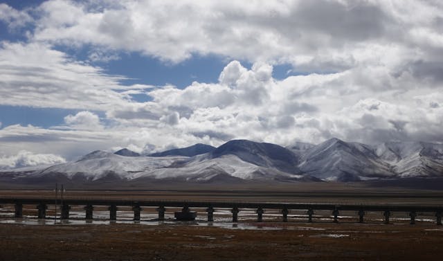 青藏鐵路興建橋墩直通地底深處的架空橋，來解決凍土不穩定的難題。