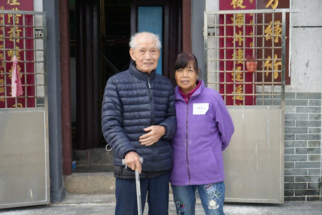 黃女士在村口檔賣食物，記者邀請她與爸爸合影，場面十分溫馨。