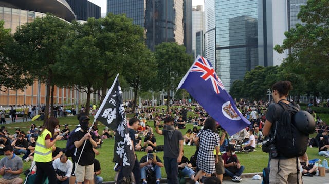 黑衣人舉起「光復香港時代革命」和港英龍獅旗。