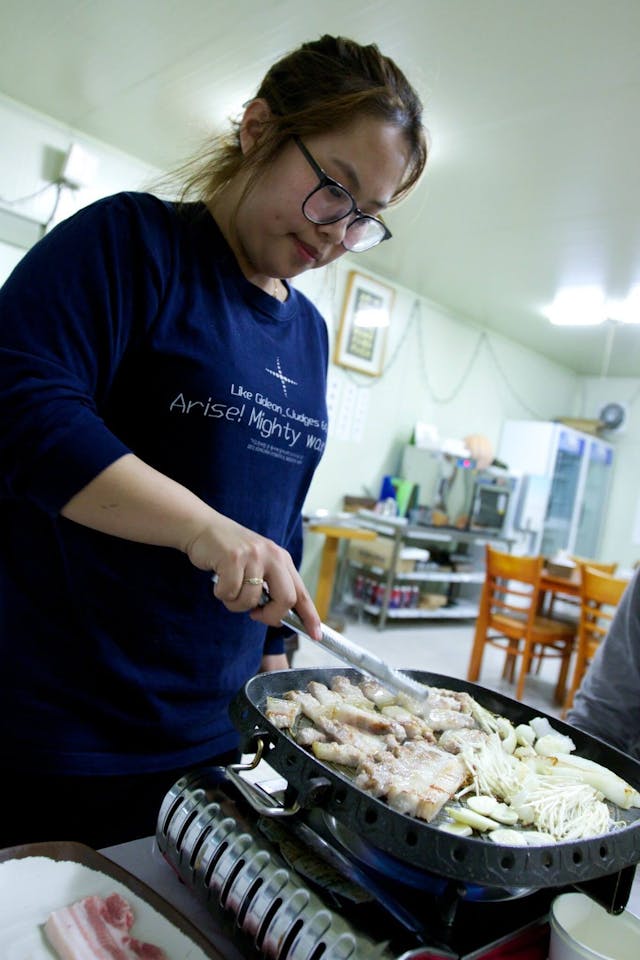 餐館老闆女兒為我們煎五花肉。