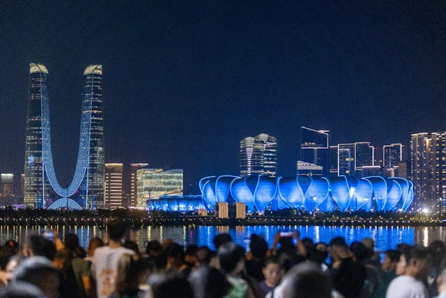 亞運開幕前夕，杭州市民急不及待拍攝運動場夜景。（亞新社）