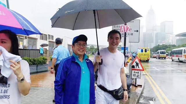 譚詠麟、鍾鎮濤冒雨前來會場。