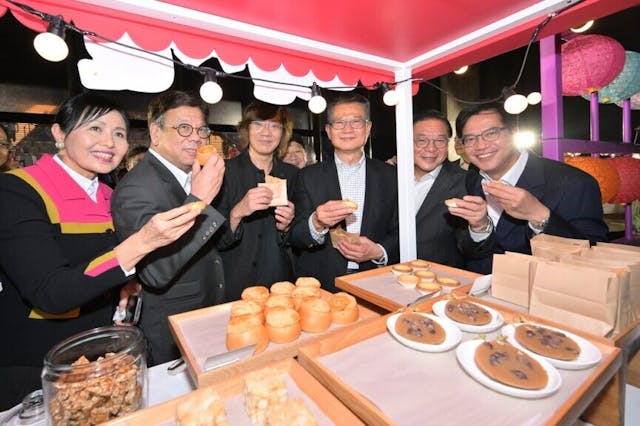 陳茂波（右三）、財政司副司長黃偉綸（右一）、商務及經濟發展局局長丘應樺（左二）和其他嘉賓在夜市品嚐美食。（政府新聞處圖片）