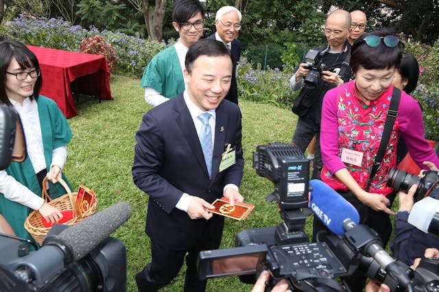 張翔校長向在場傳媒記者派「利市」，內有一張祝賀卡，憑卡領取港大紀念品。