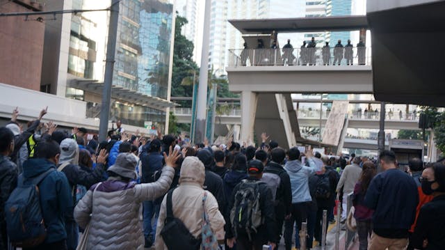 警方在軍器廠街天橋駐守。遊行人士喝罵他們。