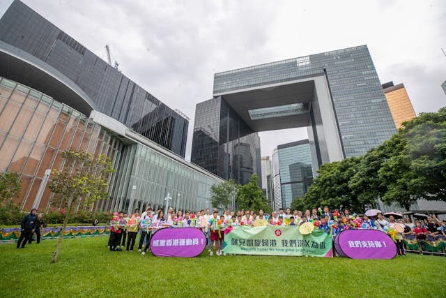 運動員與學生在添馬公園合影留念。（亞新社）