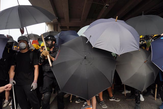 示威者用雨傘防禦。