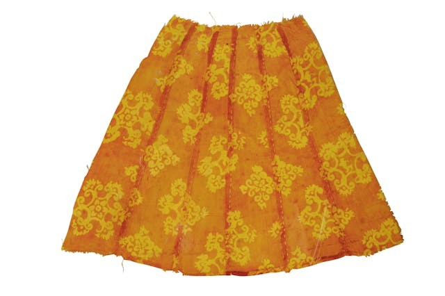 橙色印花小絹裙細小精緻，原為女舞俑衣服，卻完整保留唐代服飾的印染與織物工藝。（新疆維吾爾自治區博物館藏）