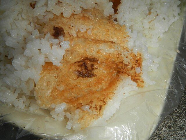 底層的鍋巴金黃酥脆,浸滿豐厚油汁,入口香醇。(Wikimedia Commons)