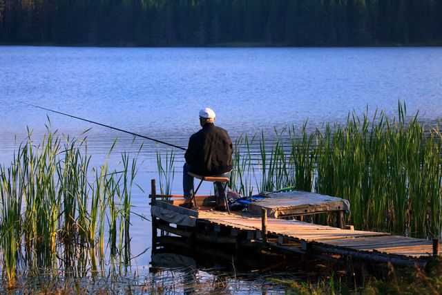 一老者正拿着一個釣竿，一把櫈子，一副耳機，自顧自咿咿呀呀，一種遠離塵世的樣子。（Shutterstock）