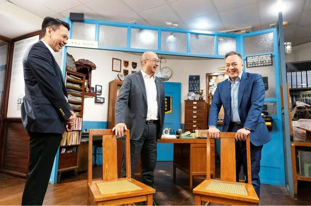 舊油麻地警署當年使用的座椅令曾任職政府的馬會公司事務執行總監譚志源(中)禁不住緬懷一番,逗得各人笑逐顏開。圖左為當日另一訪問主持人、馬會公共事務副總經理(慈善傳訊)李臻。圖右為警務處處長周一鳴。(駿步人生)